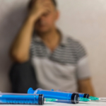 syringes in foreground with man with drug addiction in background what is the drug fentanyl